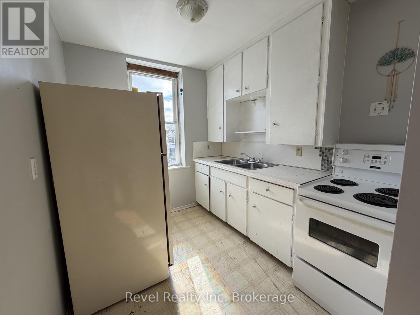 A kitchen with white cabinets and appliances.