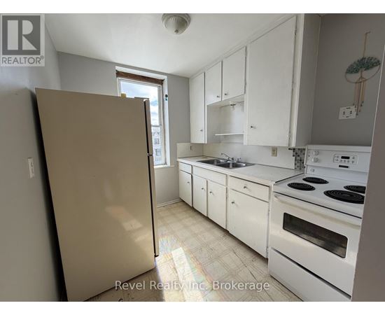 A kitchen with white cabinets and appliances.