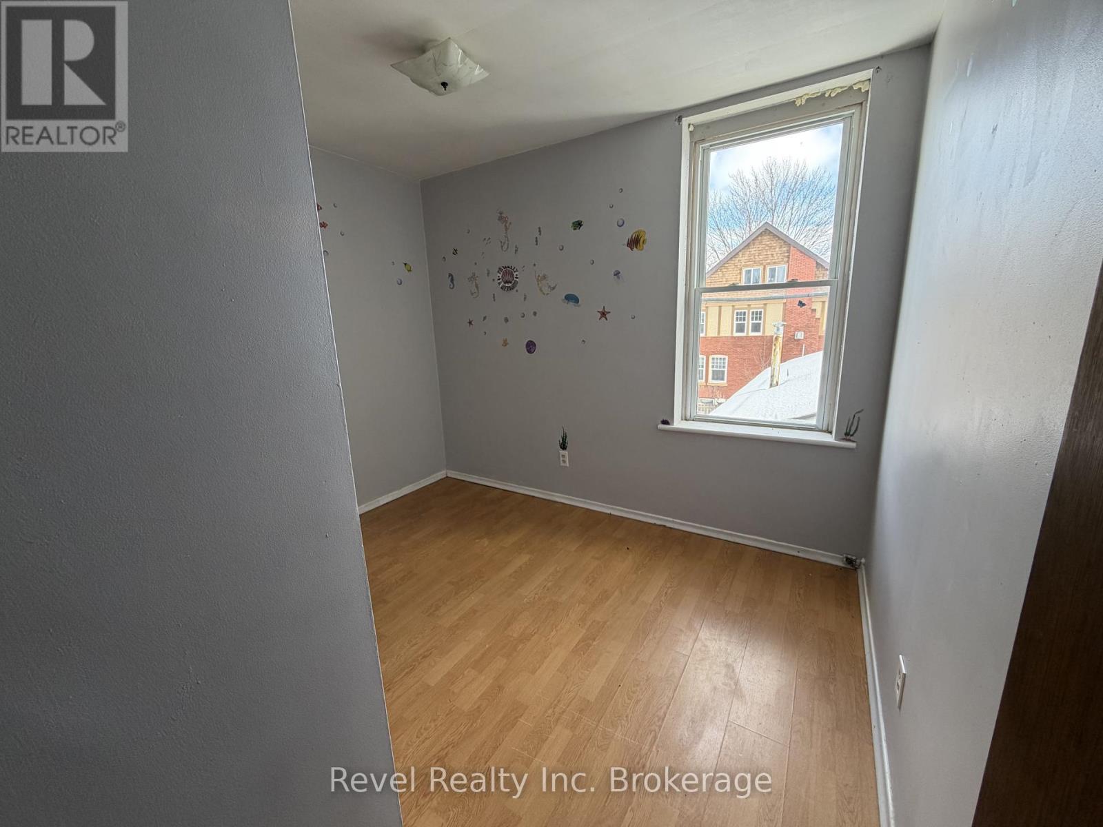 A room with a window showing a building outside.