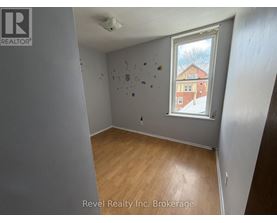 A room with a window showing a building outside.