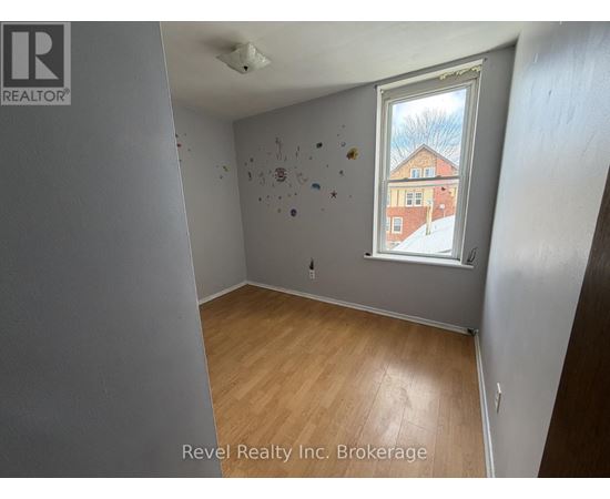 A room with a window showing a building outside.
