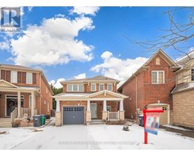 A real estate sign is in front of a house with a garage.