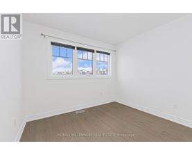 A room with a window showing a view of the sky and buildings outside.