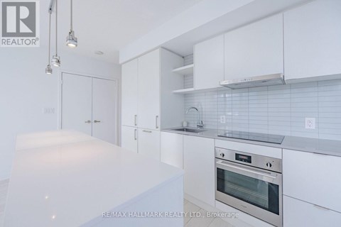 A modern kitchen with white cabinets and stainless steel appliances.