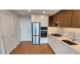 A kitchen with a stainless steel refrigerator, oven, and sink.