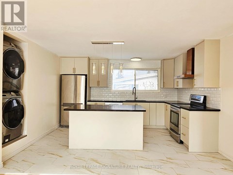 A kitchen with a black counter top and white cabinets.