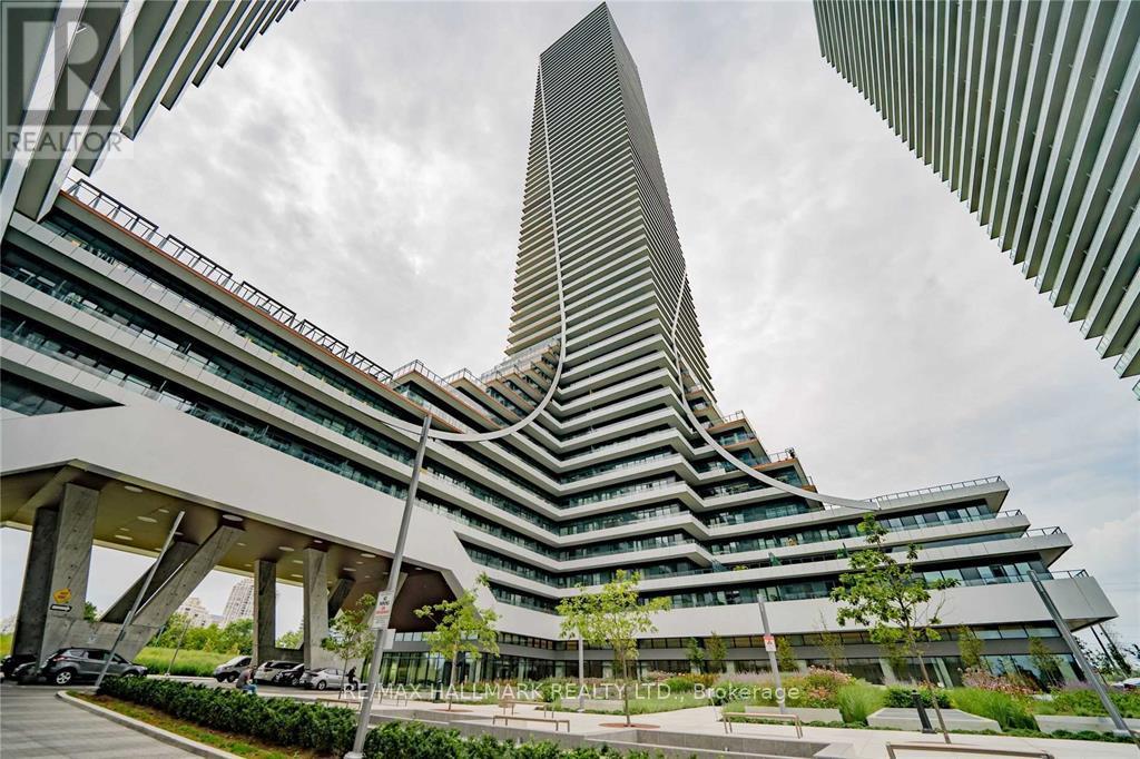 A modern building with a tall skyscraper in the background.