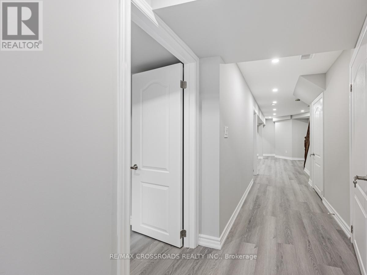 A hallway with white walls and wood flooring.