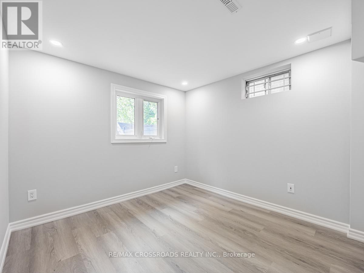 A room with a window and a wooden floor.