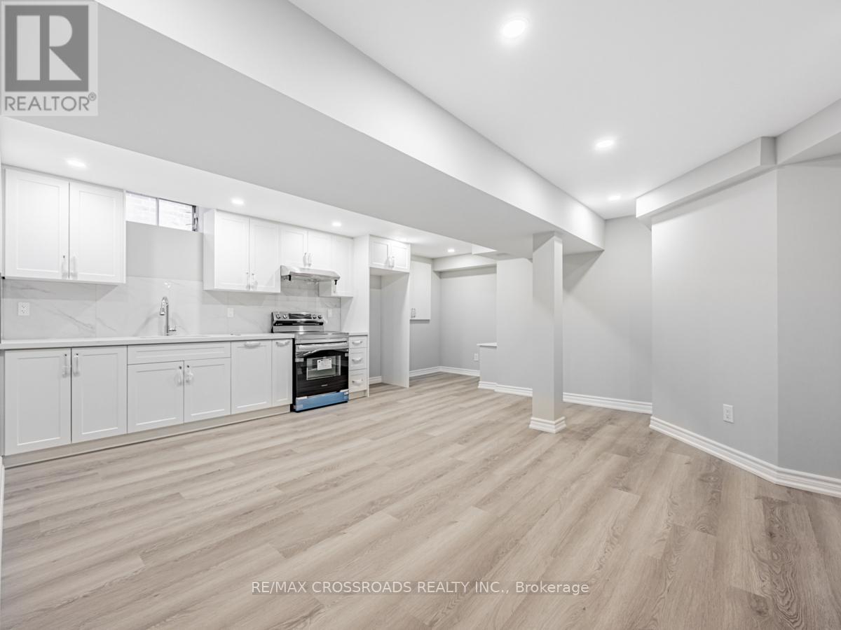 A spacious kitchen with white cabinets and a wooden floor.