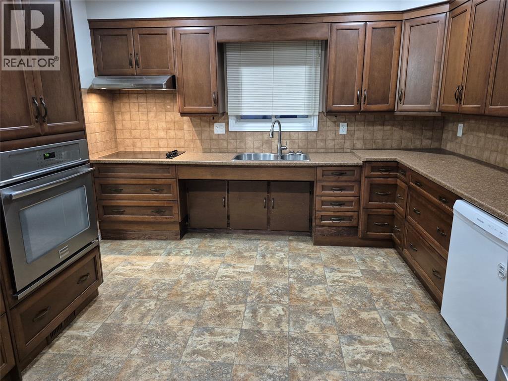 A kitchen with wooden cabinets and a tile floor.