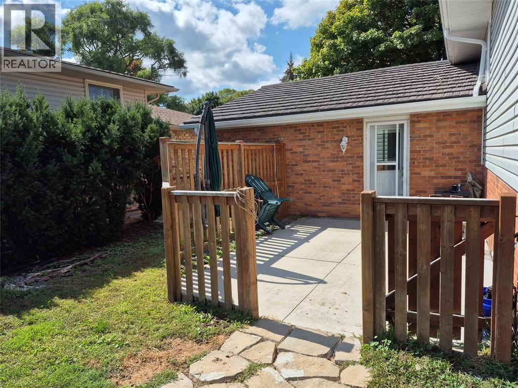 A backyard with a wooden fence and a patio table.