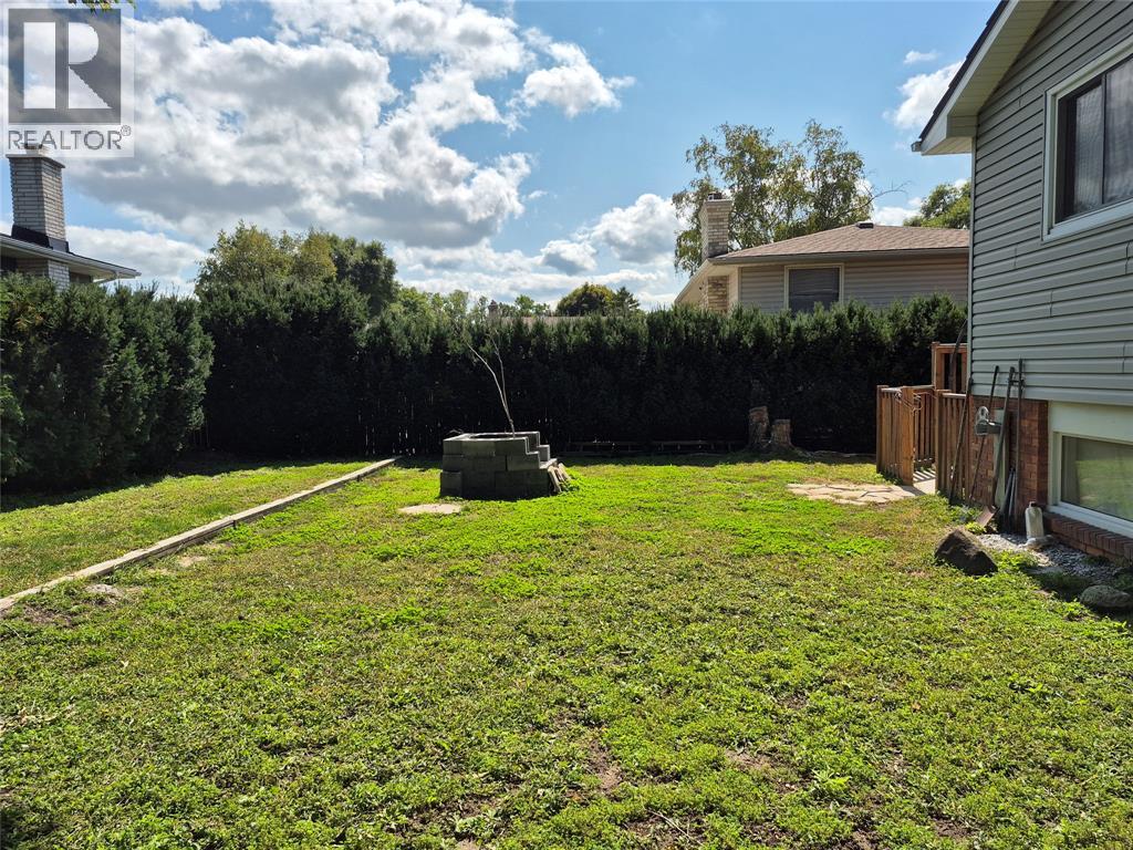 A backyard with a lawn and a fence.