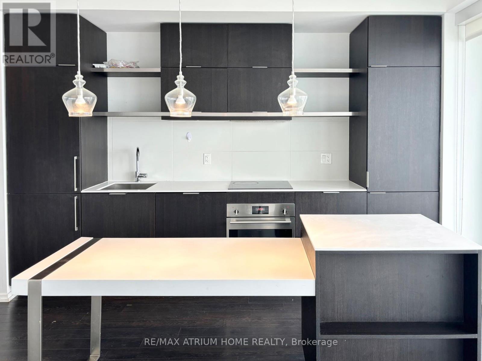 A modern kitchen with a wooden countertop and black cabinets.