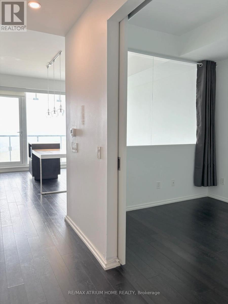 A room with a white door and a grey curtain.