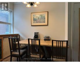 A dining room with a wooden table and chairs.