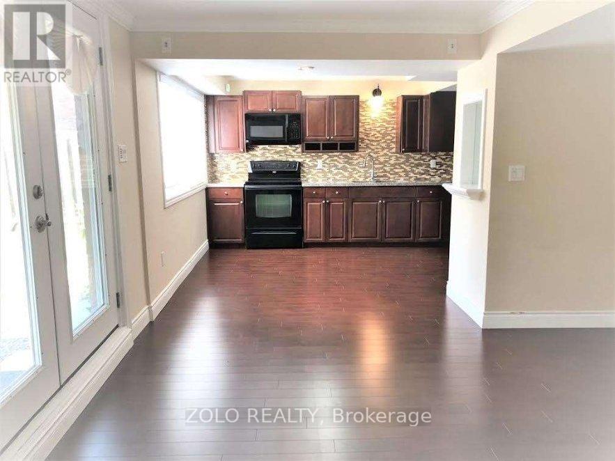 A kitchen with wooden cabinets and a black stove top oven.