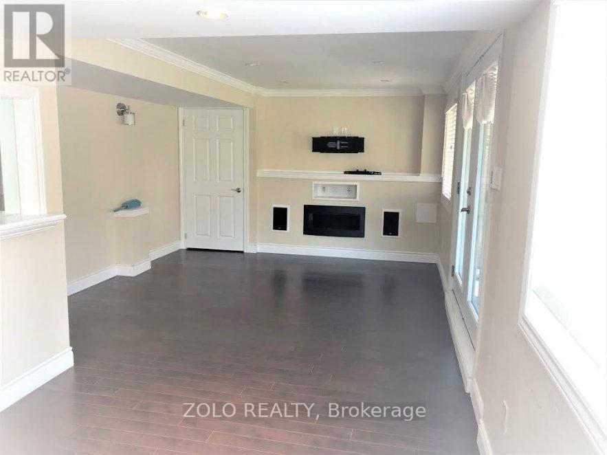 A spacious room with a flat screen TV mounted above a built-in cabinet.
