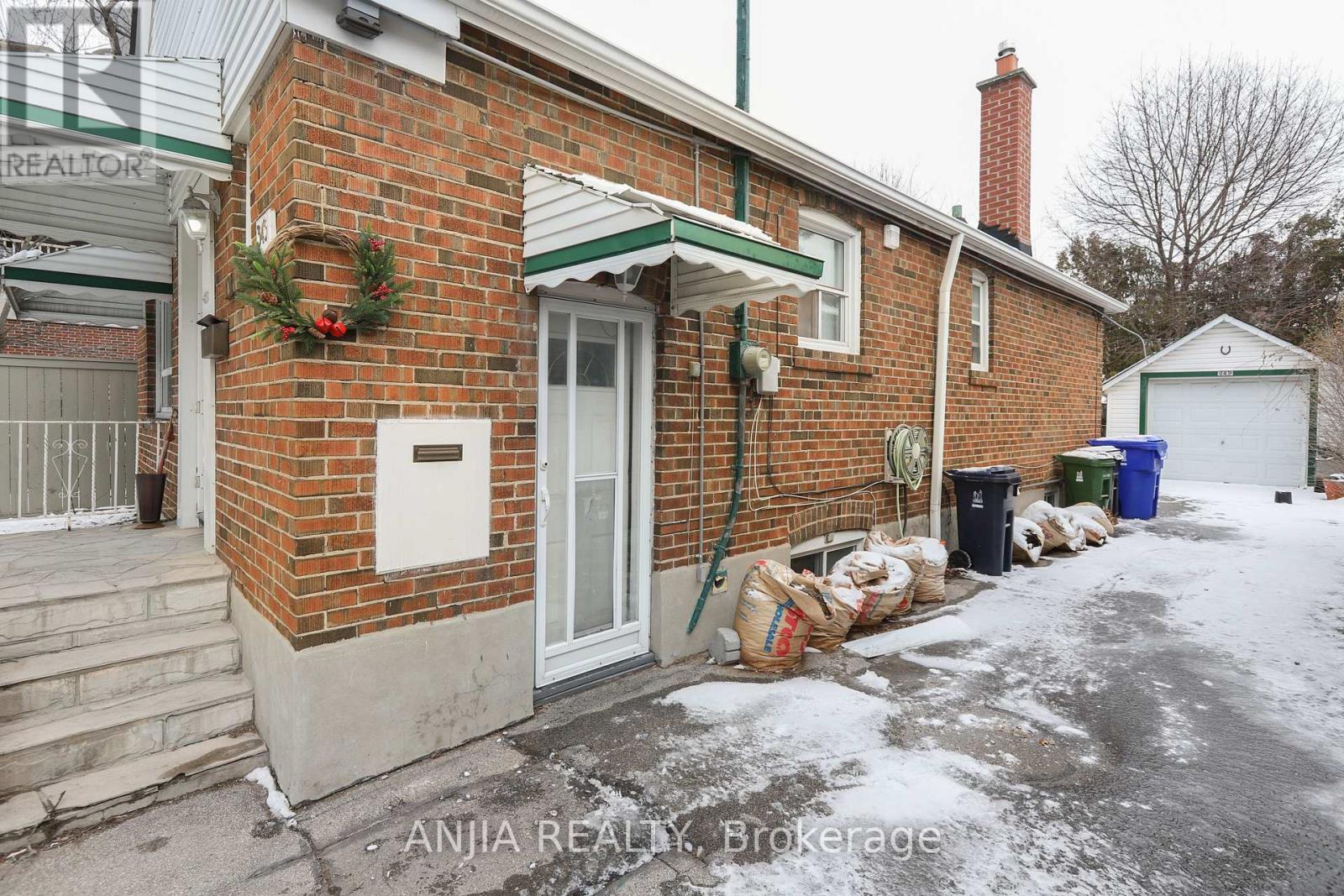 A red brick house with a green roof and a white door.