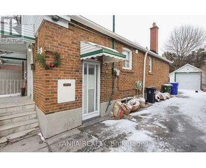 A red brick house with a green roof and a white door.