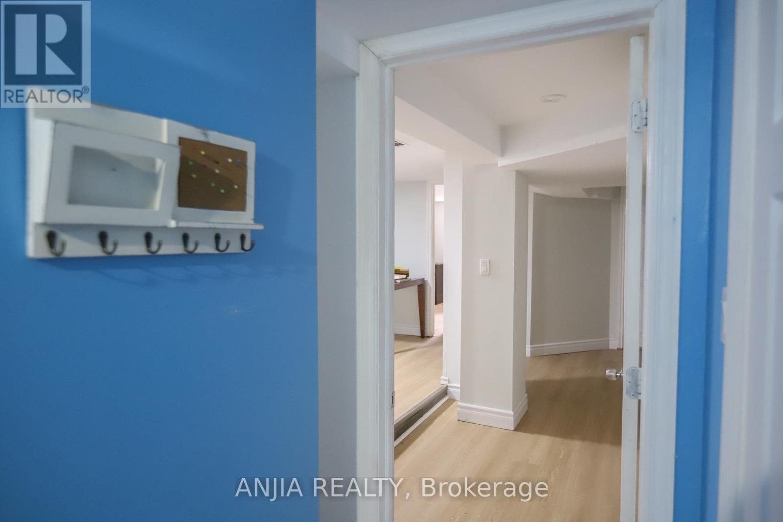 A white microwave oven is mounted on a blue wall.