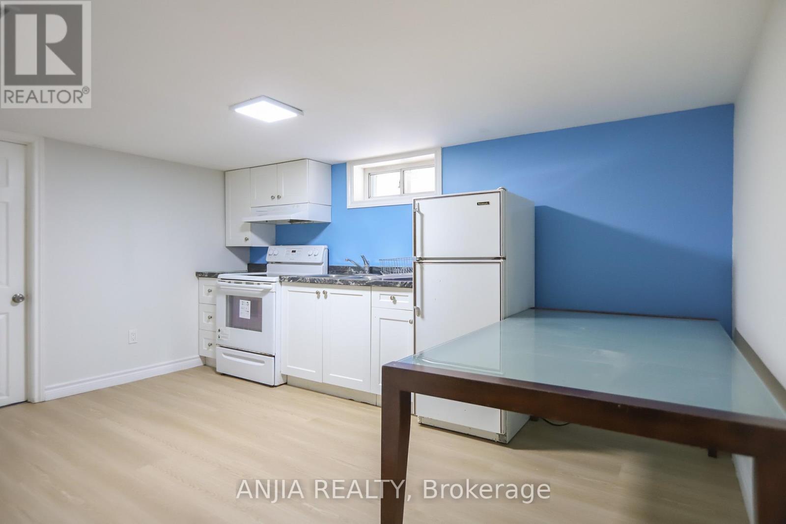 A kitchen with white appliances and a blue wall.