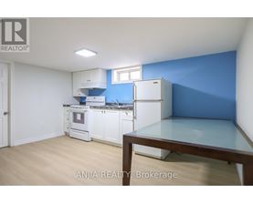 A kitchen with white appliances and a blue wall.