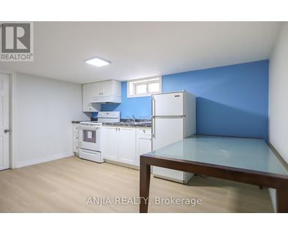 A kitchen with white appliances and a blue wall.