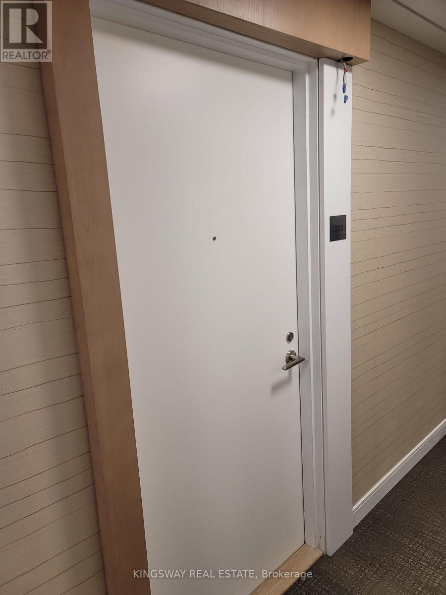 A white door with a handle and a small square on the wall.