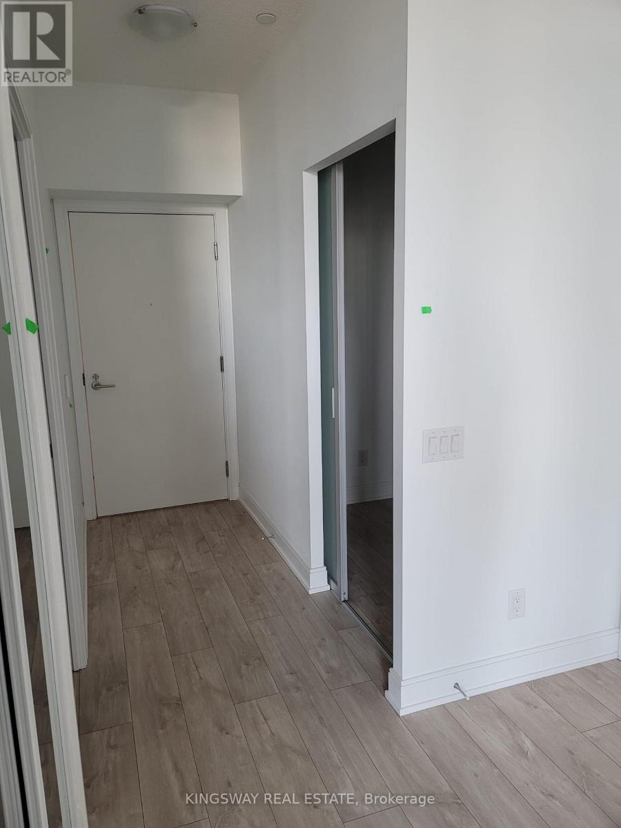 A room with a white door and a white wall with a logo on it.