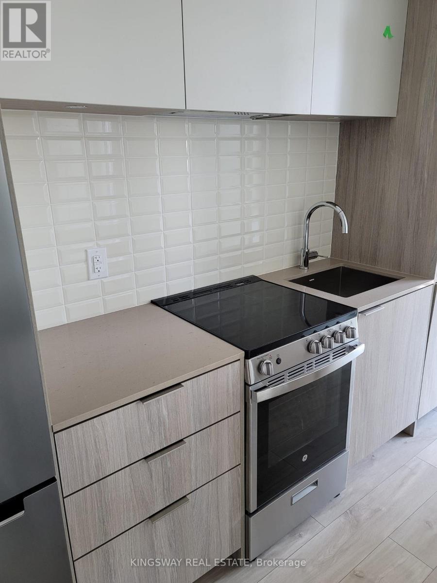 A kitchen with a stove top oven and a sink.