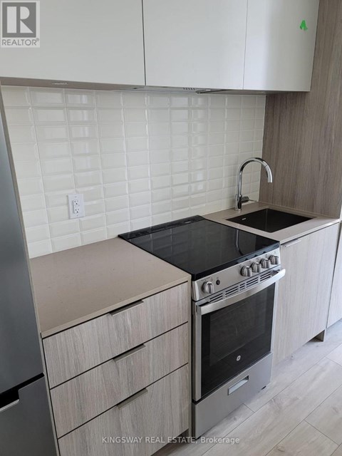A kitchen with a stove top oven and a sink.