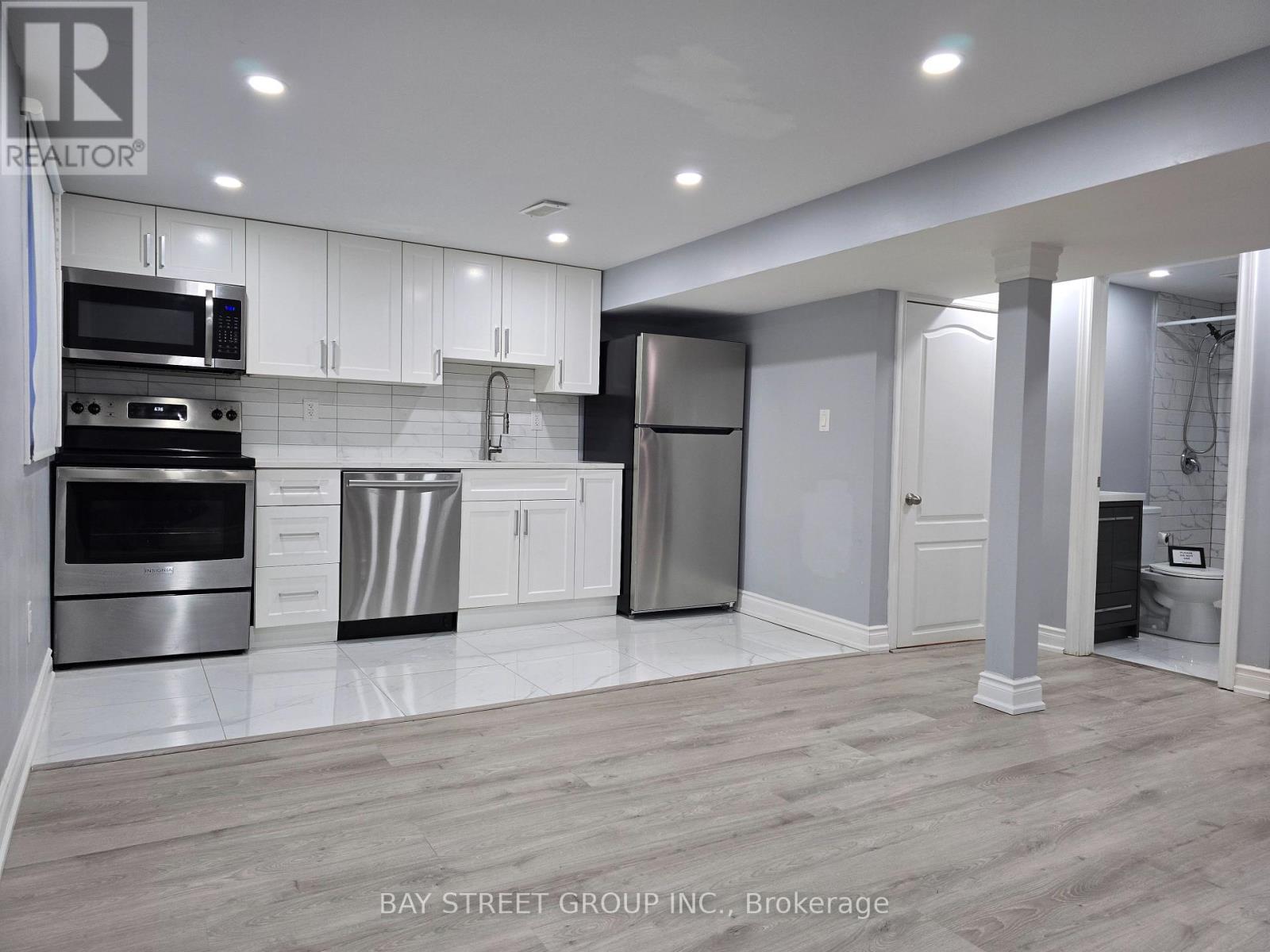 A modern kitchen with white cabinets and stainless steel appliances.