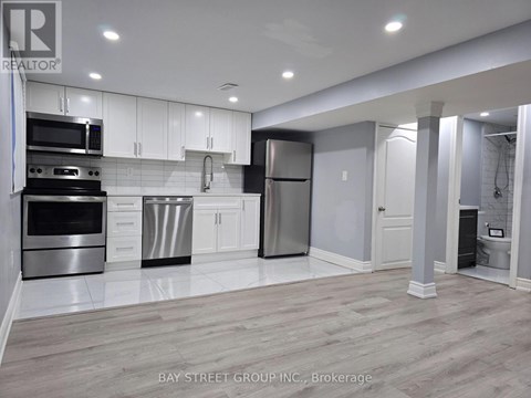 A modern kitchen with white cabinets and stainless steel appliances.