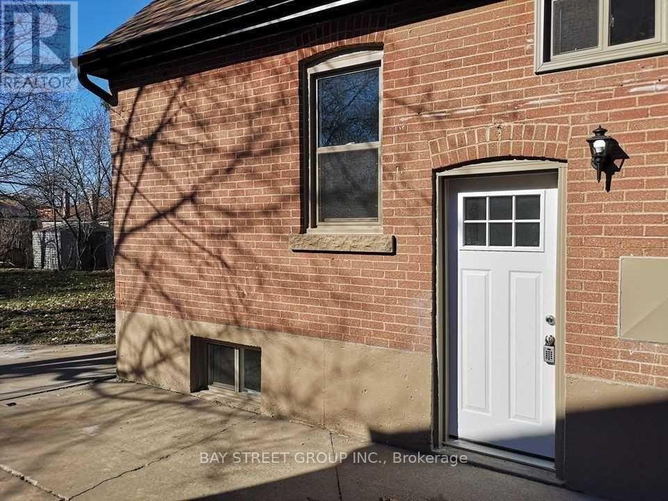 A red brick house with a white door and a window.