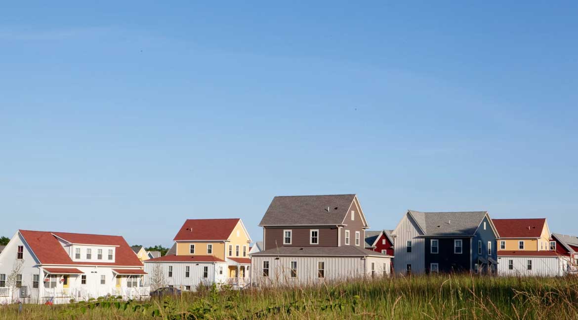 A row of houses with different colored roofs.