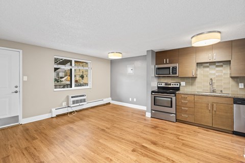A kitchen with wooden floors and a white door.