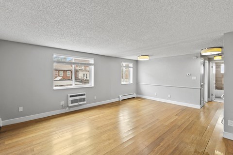 A room with wooden floors and a picture of a house on the wall.