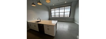A kitchen with white cabinets and a large window.