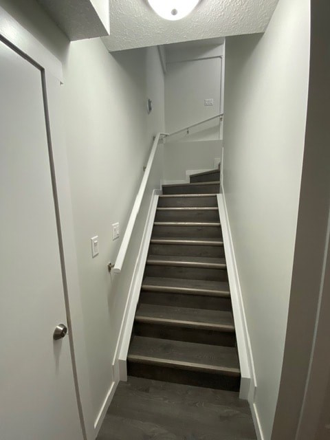 A staircase with a white door on the left side.