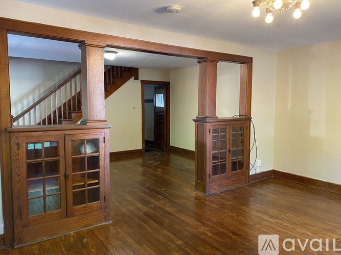 A room with wooden floors and a staircase with wooden railings.