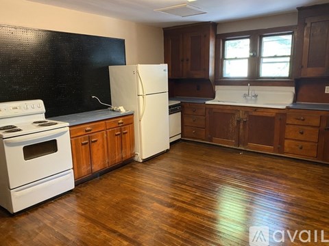 A kitchen with wooden floors and white appliances.