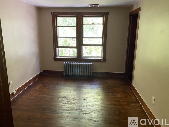 A room with a window and a radiator on the floor.