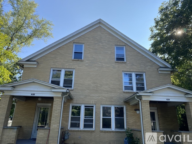 A two-story house with a brick facade and multiple windows is for sale.