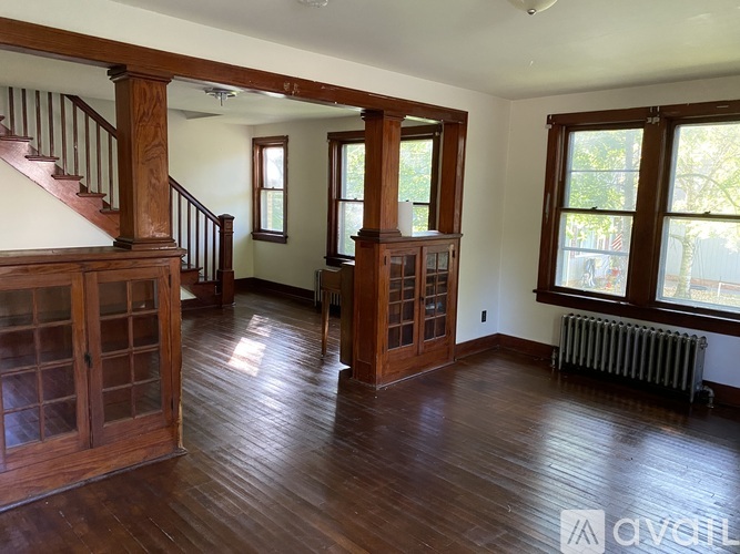 A living room with wood floors and a staircase.