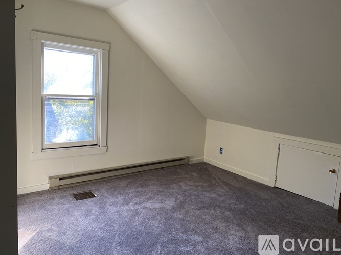 A room with a window and a door is available for rent.