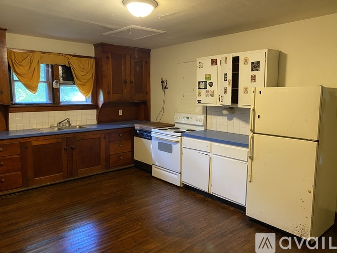 A kitchen with white appliances and wooden cabinets.