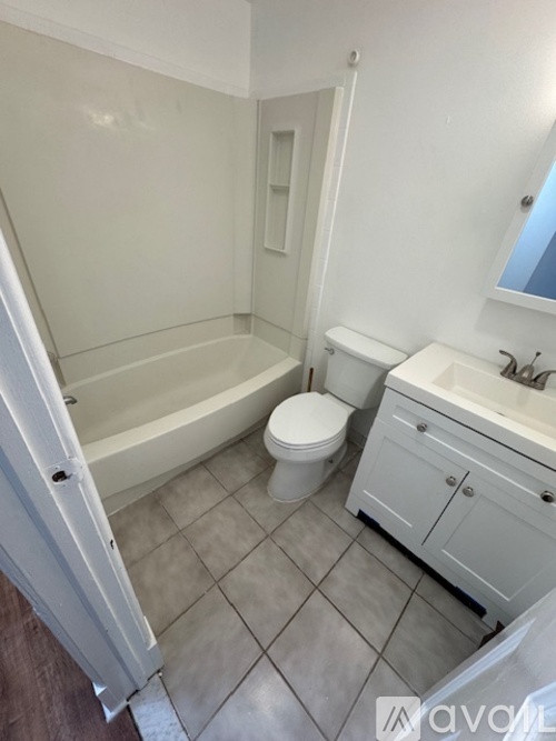 A white bathroom with a toilet, sink, and bathtub.