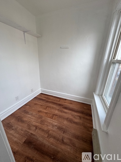 A room with wooden flooring and white walls.