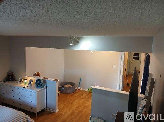 A bedroom with a white dresser and a grey desk.